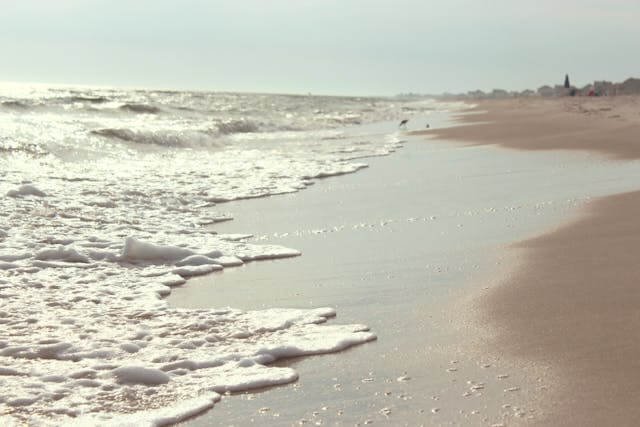 Image of ocean waves breaking onto the shore at a beach.
